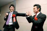 巨人・坂本勇人内野手（左）が、プロボクシングの西岡利晃（右）にパンチを受けてもらう。