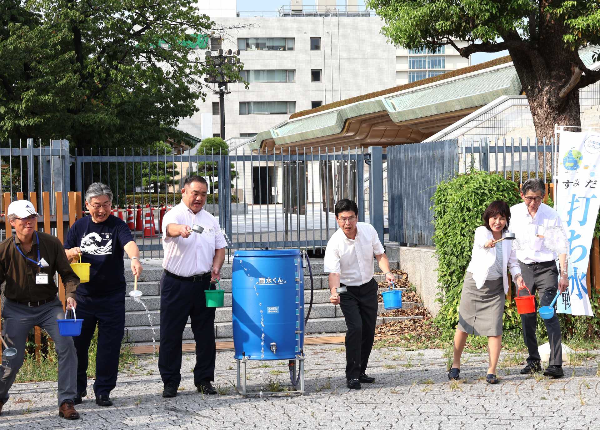 打ち水イベントに参加した西岩親方（左から２人目）と墨田区・山本亨区長（同４人目、右は土橋秀規副区長、同２人目は岸川紀子副区長、左は岩下弘之資源環境部長、同２人目は東京東信用金庫・吉田誠理事長）