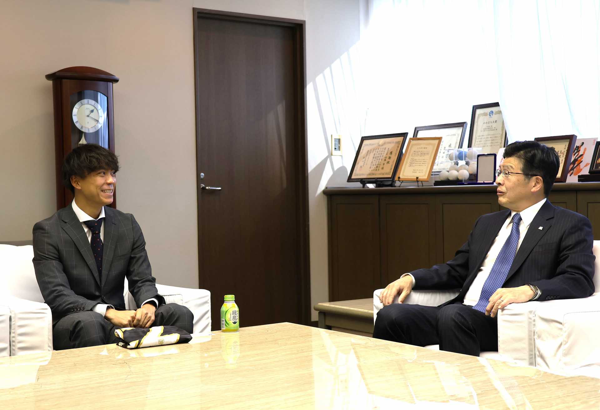 山本区長（右）と談笑する栃木シティＦＣのＤＦ鈴木裕斗