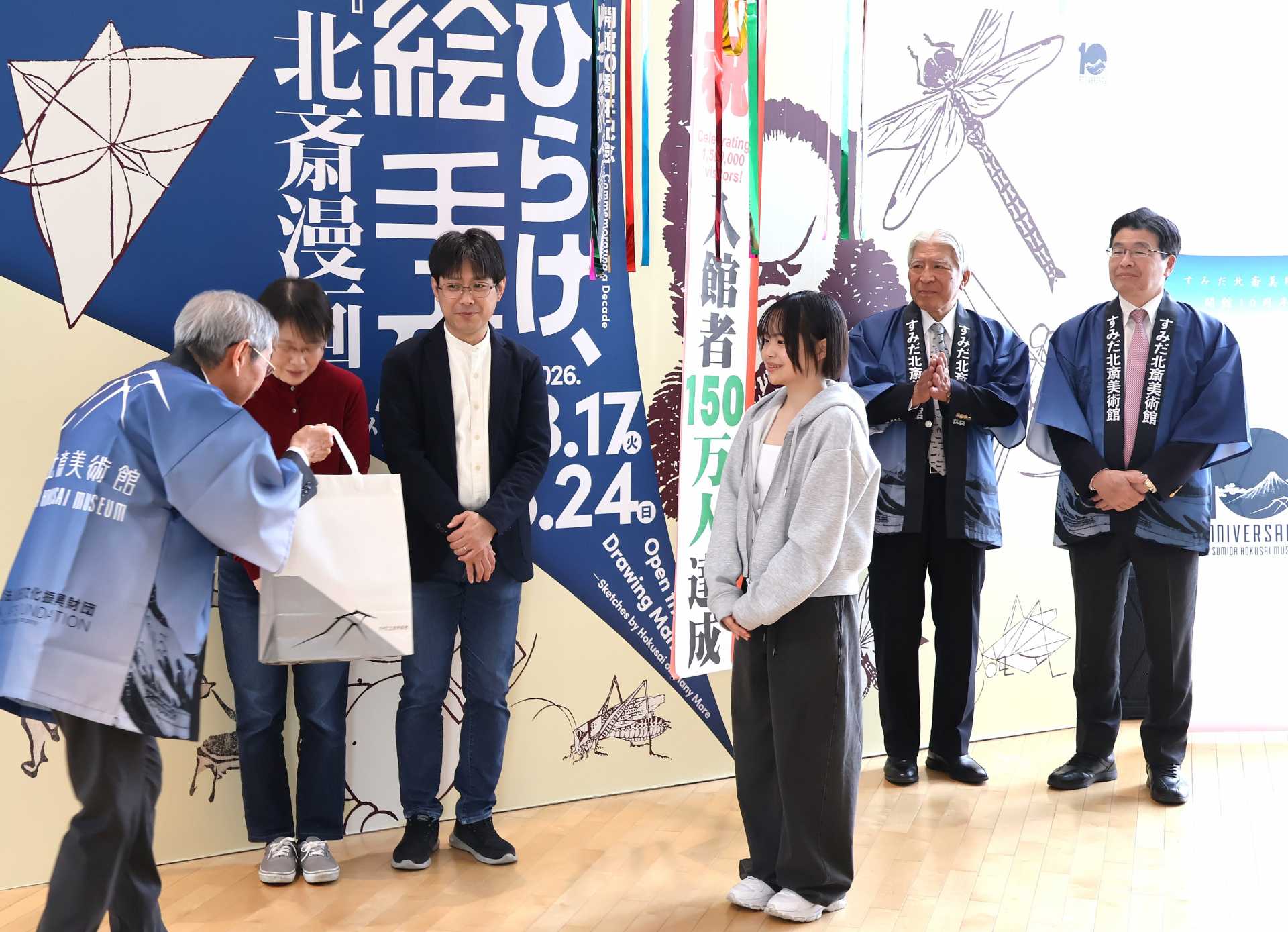 大久保館長（左）から年間パスポートなどを手渡された南和歌菜さん