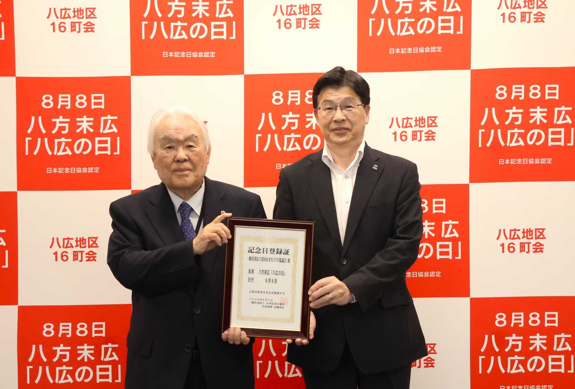 八広誕生６０周年にあたり８月８日を「八方末広『八広の日』」として日本記念日協会に申請、登録証を手にする山本亨区長（右）と「八広八・八祭り実行委員会」泉幸延実行委員長