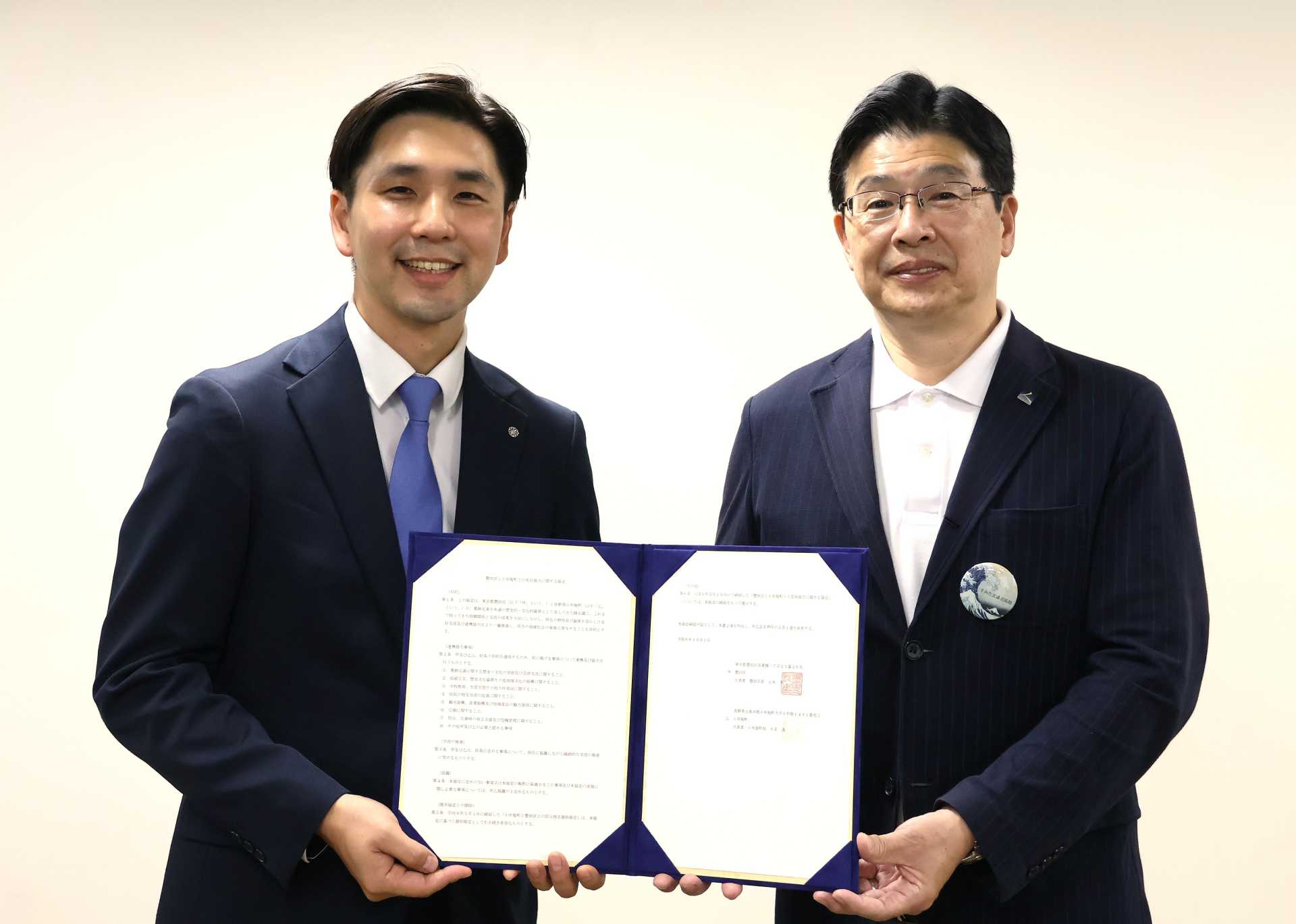 改めて結び直した友好協力協定を手にする小布施町・大宮透町長（左）と墨田区・山本亨区長（右）